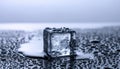 Melting ice cube on wet dark surface with water droplets, close-up Royalty Free Stock Photo