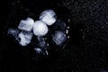 Melting ice cubes and water drops on black background, top view. Royalty Free Stock Photo