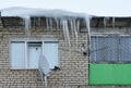 Melting icicles on a satellite and television antenna on a wall of a multistory building Royalty Free Stock Photo