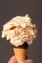 Melting raspberry ripple ice cream about to run down the cone