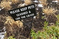 Melting snow on the ground, into which a sign has been stuck prohibiting dogs from walking on the lawn Royalty Free Stock Photo