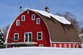 Melting snow on roof of an old red barn