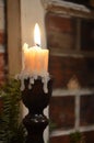 Melting white candlestick in wooden holder