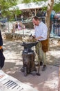 Member of the annual festival of Knights of Jerusalem, dressed as a blacksmith forges iron detail