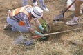 A member of the Clean & Green environmental group of the Los Angeles Conservation Corps plants a tree in a hole dug by another