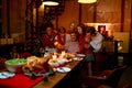 Member in family join to stand and hug near grandfather to celebrate Christmas festival at home and night time during dinner party