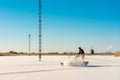 Member of ice skating club dusts off snow of natural ice skating rink in Grootschermer Netherlands