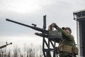 Member of the mobile air defence group checks a DShK machine gun atop of a pick up truck in the Hostomel town, Ukraine Royalty Free Stock Photo