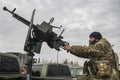 Member of the mobile air defence group checks a DShK machine gun atop of a pick up truck in the Hostomel town, Ukraine Royalty Free Stock Photo