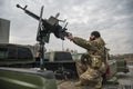Member of the mobile air defence group checks a DShK machine gun atop of a pick up truck in the Hostomel town, Ukraine Royalty Free Stock Photo