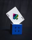 Memento mori playing card on a blue cube against a dark background.