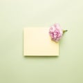 Memo pad with carnation flower on light green background Royalty Free Stock Photo
