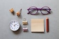 Memo pad, pencil, clock, clip, glasses on gray background Royalty Free Stock Photo