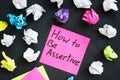 Memo with sign How to be Assertive