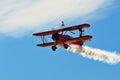 Memorial Airshow. Red Stearman biplane flying towards camera while trailing smoke in exhibition Royalty Free Stock Photo