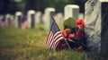 A grave with an american flag and colorful flowers are noticeable in the background for memorial day