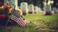 A grave with an american flag and colorful flowers are noticeable in the background for memorial day