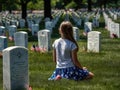 Memorial Day. A girl in front of a headstone during Memorial Day as visitors honor veterans at Cemetery in