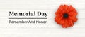 Memorial Day - Remember and Honor Poster. Large Red Poppy Flower on the background of light planks and congratulatory text