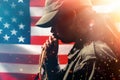 Memorial day, veterans day. Portrait of Soldiers a woman holds a rosary and prays, raising them to her mouth. American flag on the Royalty Free Stock Photo