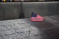 Memorial at Ground Zero Manhattan for September 11 Terrorist Attack with an American Flag Standing near the Names of Victims Engra