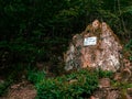 Memorial stone with a sign in the forest \