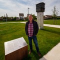 A Zedelgem Councillor stands by the Beehive Memorial to the Latvian Prisoners of War at the nearby POW Camp