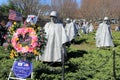 Memorial wreaths and flags near Statues of soldiers standing in rough terrain,Korean War Veteran's Memorial,Washington,DC,2015