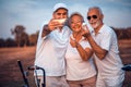 Memories on the court. Senior golfers using phone and taking self portrait. Focus is on background Royalty Free Stock Photo