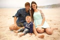 Memories made at the beach last a lifetime. Portrait of a young couple and their son sitting on the beach.