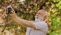 Memories in snap. Everyone photogenic. Senior man taking selfie photo vintage camera. Retro equipment for taking photo Royalty Free Stock Photo