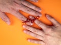 Memory and Reminder Knot. Female and male hands on an orange background