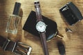 Men accessories: perfume, watch and belt on wooden background