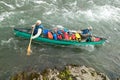 Men in adventure canoe on Alaskan river rapids