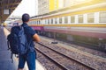 Men backpacker waiting for his train in railway station . Royalty Free Stock Photo