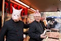 Men on barbecue costumed as pigs Royalty Free Stock Photo