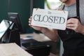 Men barista holding sign wooden text open, welcome entrance shop