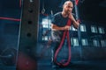 Men with battle rope battle ropes exercise in the fitness gym. CrossFit. Royalty Free Stock Photo