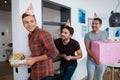 Men in birthday hats are preparing a surprise birthday party. They are preparing to meet the birthday girl. Royalty Free Stock Photo