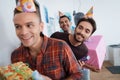 Men in birthday hats are preparing a surprise birthday party. They are preparing to meet the birthday girl. Royalty Free Stock Photo