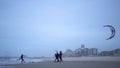 Men in black suits go kitesurfing.Extreme sports,kiteboarding on vacation on sandy beach in windy weather.Beautiful foto in cloudy