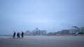 Men in black suits go kitesurfing.Extreme sports,kiteboarding on vacation on sandy beach in windy weather.Beautiful foto in cloudy