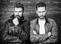 Men brutal bearded hipster posing in fashionable black leather jackets. Leather fashion menswear. Handsome stylish and Royalty Free Stock Photo