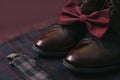 Men burgundy suit, bow tie and vintage leather shoes on textile tweed background Royalty Free Stock Photo