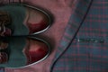 Men burgundy suit, bow tie and vintage leather shoes on textile tweed background Royalty Free Stock Photo