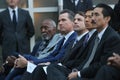 men in business suits are sitting down for the ceremony to begin