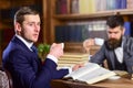 Men with busy faces reading books, studying and drink tea. Royalty Free Stock Photo