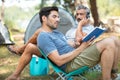 men on camping holiday reading book