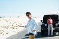 Men, car and hitchhiking in road for help or engine problem on roadtrip or journey outdoor in desert. People, travelers