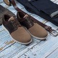 Men casual outfit. Men`s shoes, clothing and accessories on wooden background - jeans, shirt, sneakers, belt. Top view. Flat lay Royalty Free Stock Photo